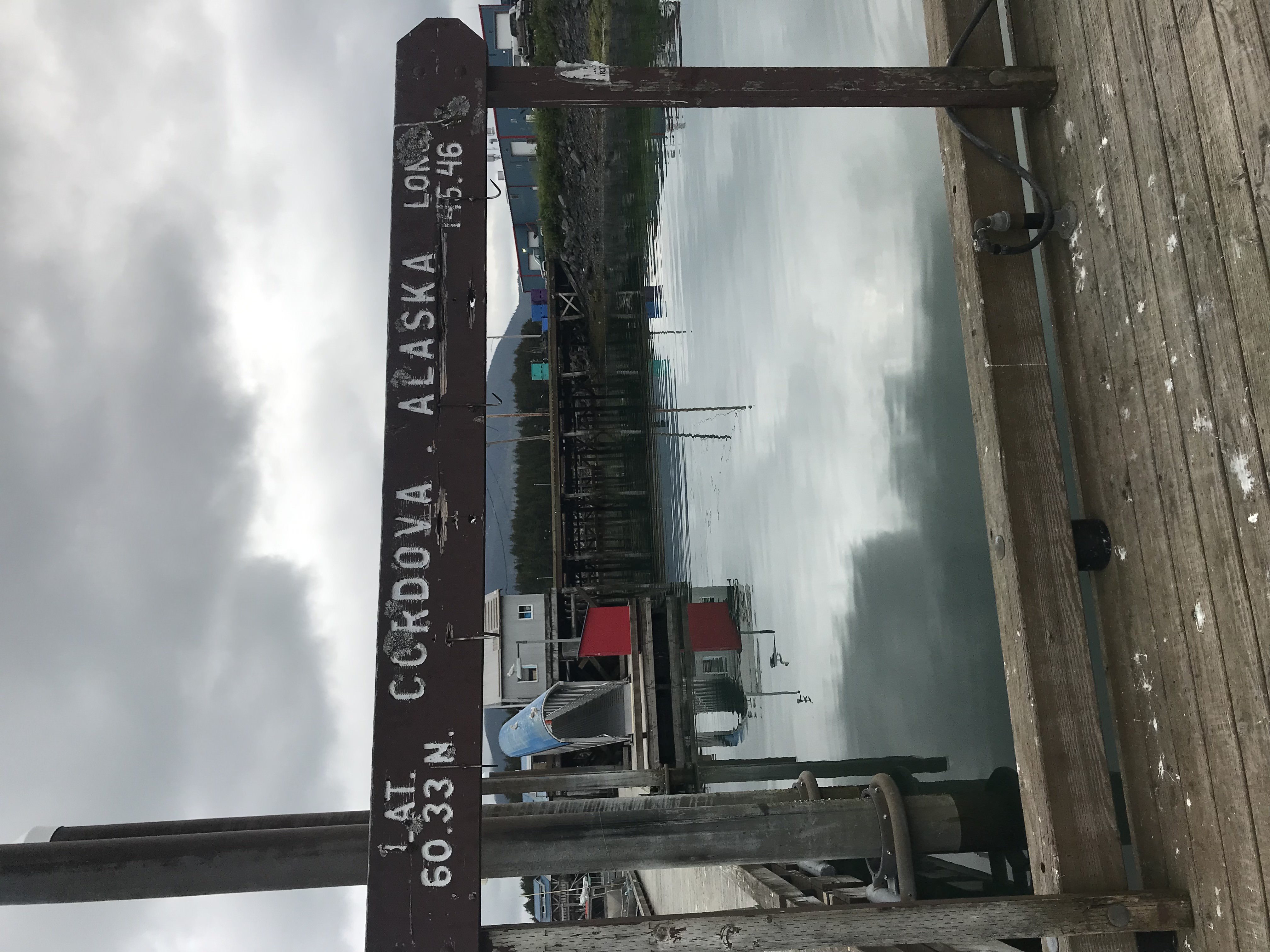 Sign with the lat and long of Cordova in the harbor.